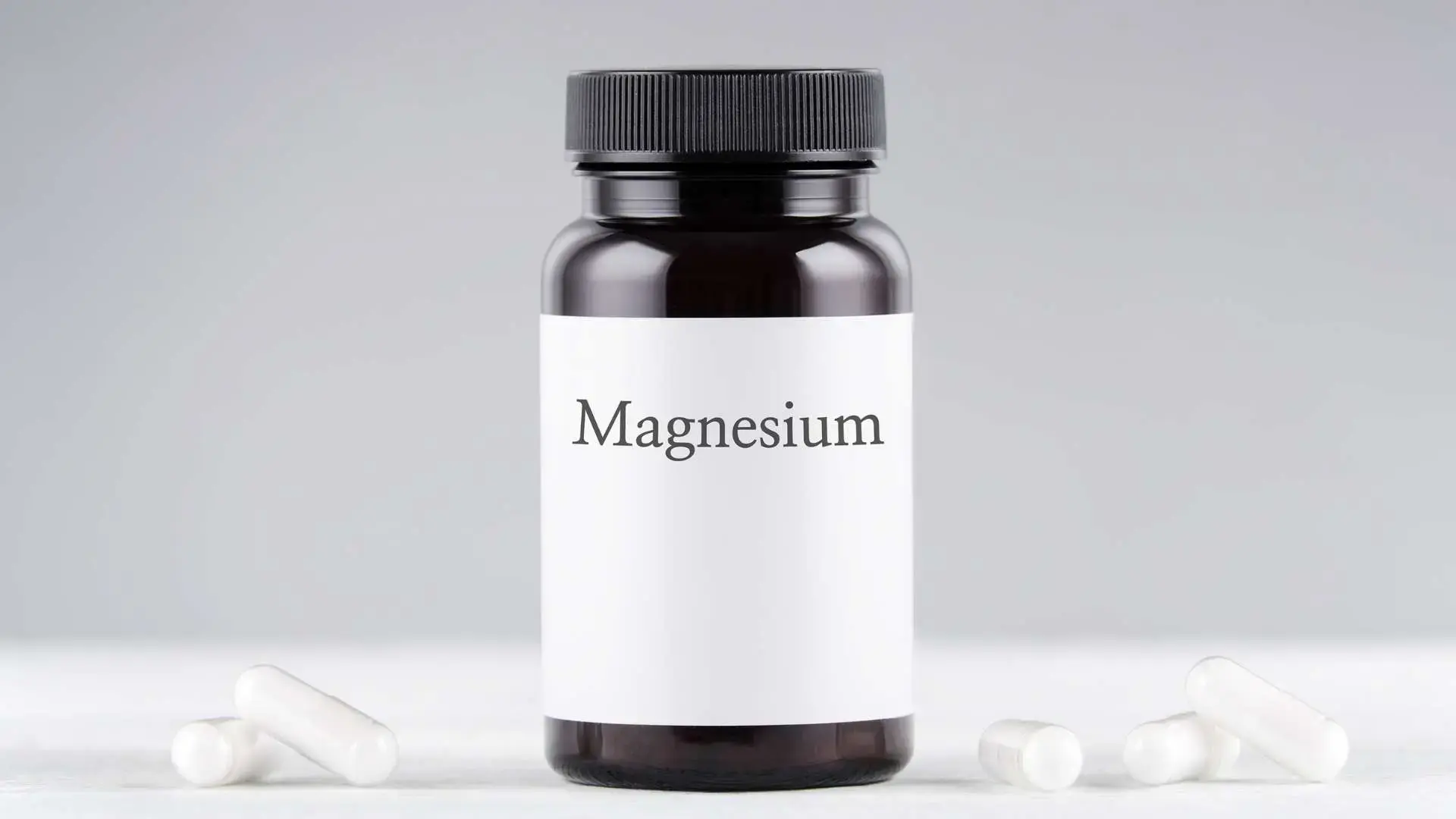 Flacon magnésium avec gélules blanches autour