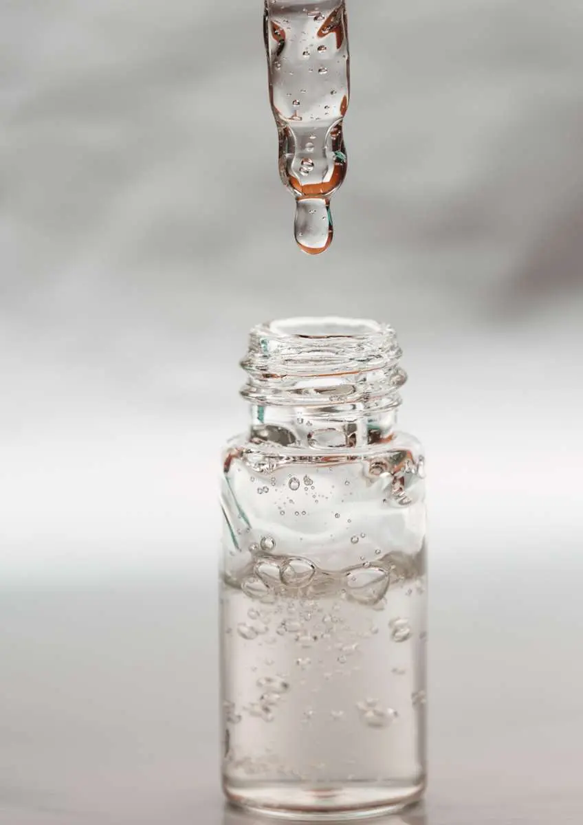 Flacon transparent d'acide hyaluronique avec pipette qui goutte au-dessus