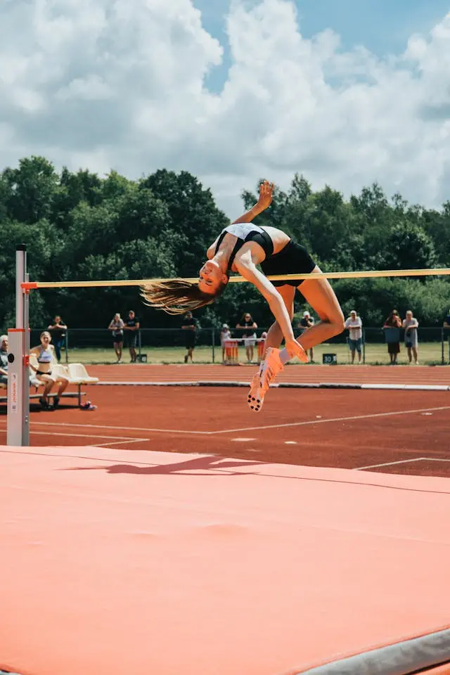 Femme athlète en plein saut en hauteur