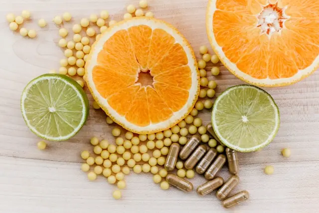 Compléments alimentaires avec deux moitiés d'oranges et deux moitiés de citrons verts