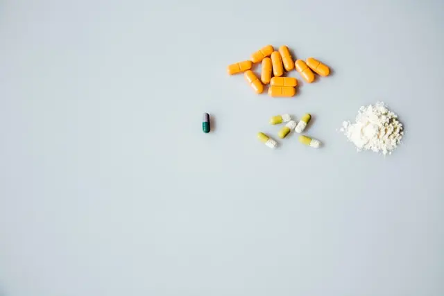 Vue de haut compléments alimentaires différentes formes galéniques sur fond gris clair